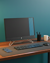A HP desktop with a keyboard, mouse, and mug on a desk with a teal wall background