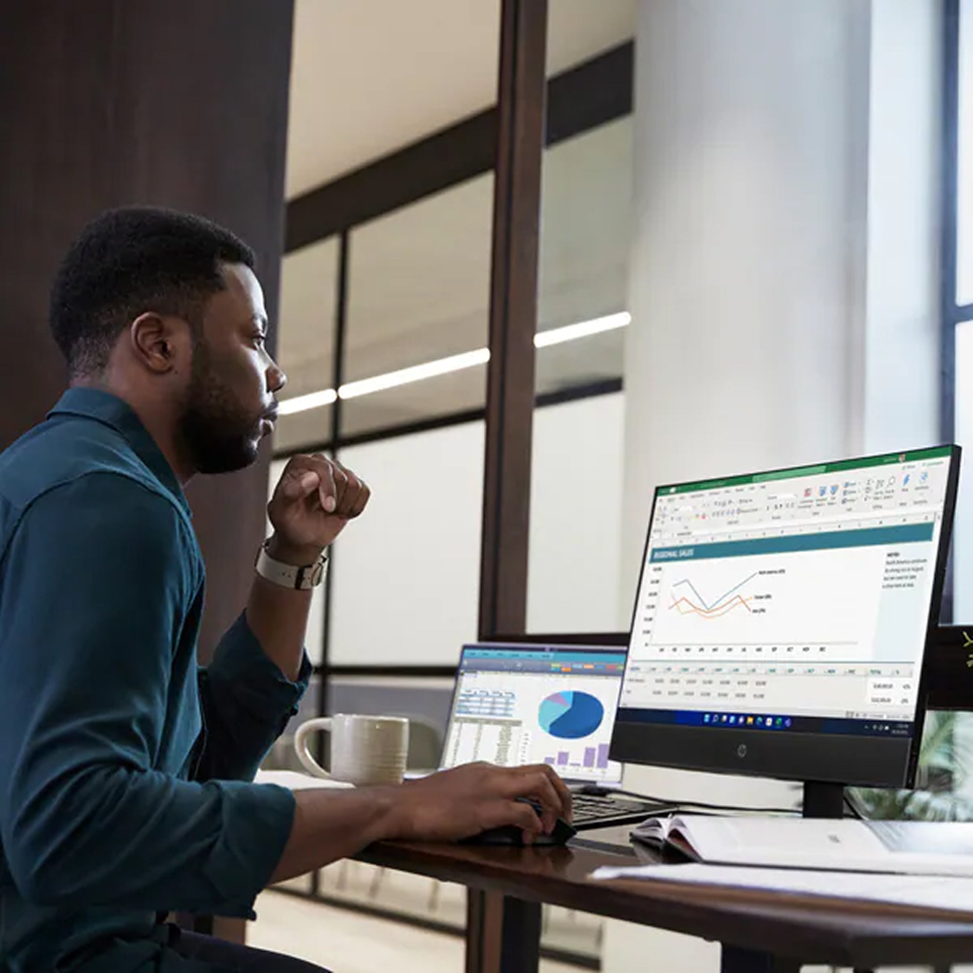 Man working at a desk with multiple computer monitors displaying financial data.